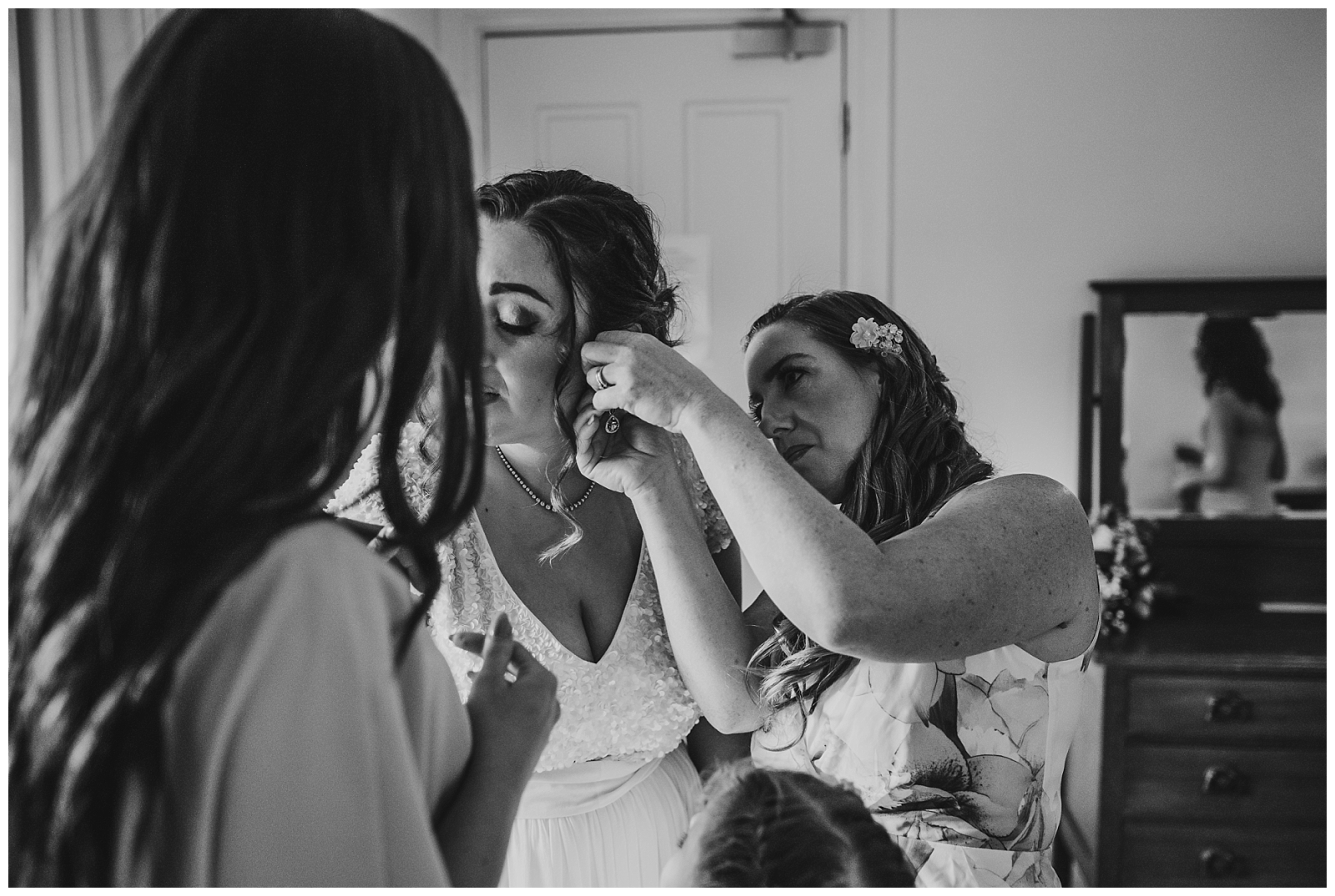 Black and white images of Step mother of the bride helping Bride to put earring in.